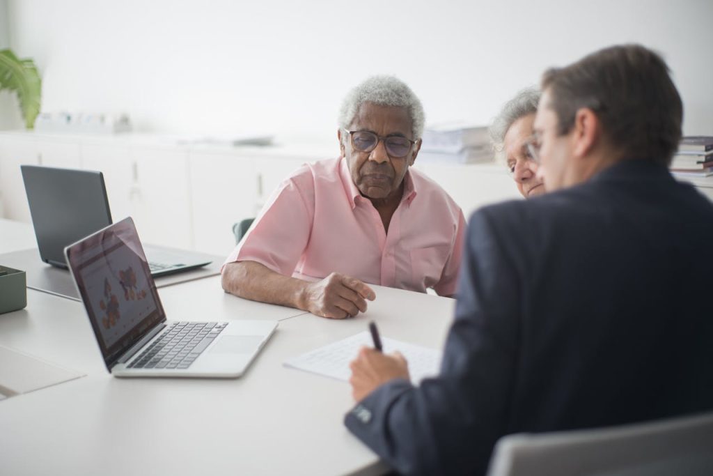 Senior couple discussing insurance options with a consultant in an office setting.